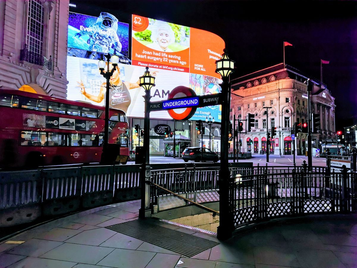 Piccadilly Circus at night, with its lights and the Underground entrance.