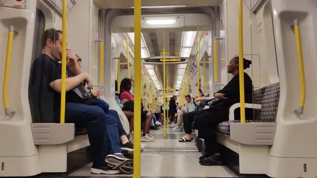 People commuting on a London underground train, showcasing city life.