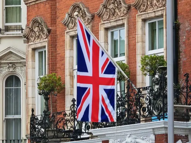 A Union flag on the front of a historic building in England.