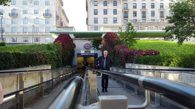 People walking towards a London subway entrance during daylight.