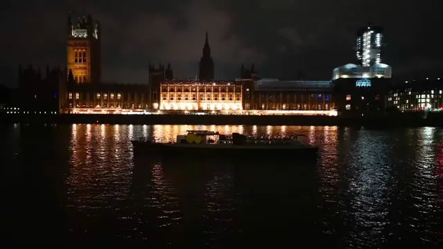 Night view of Westminster Palace and River Thames illuminated, London landmark.