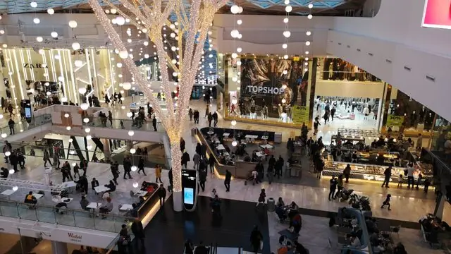 A indoor scene capturing shoppers and Christmas decorations at Westfield London.
