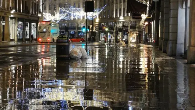 A rainy night scene with Christmas lights on Regent Street, London.