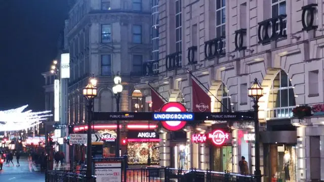 London street with Underground sign at night.