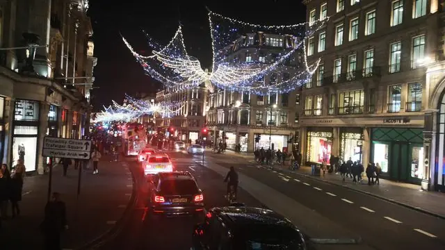 Capture the magic of London's bustling streets adorned with Christmas lights at night.