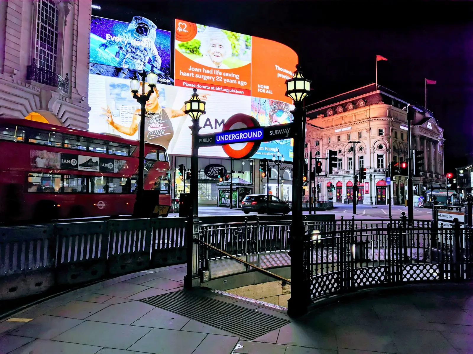 Piccadilly Circus at night, with its lights and the Underground entrance.. Photo by George Morina.