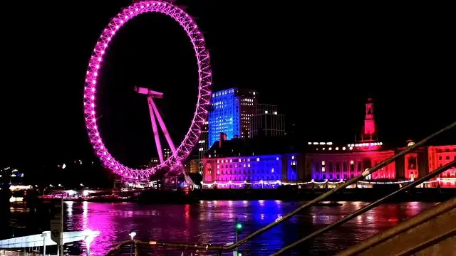 Timelapse of the brightly lit London Eye and River Thames at night.