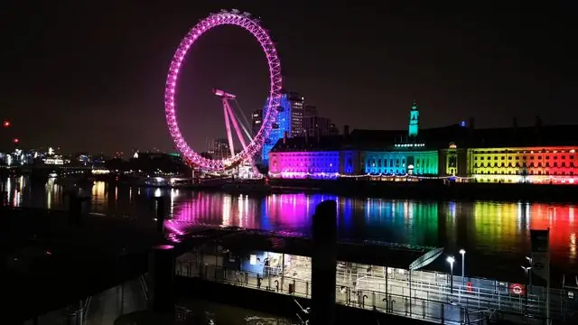 Nightscape of the London Eye with reflections on the Thames.