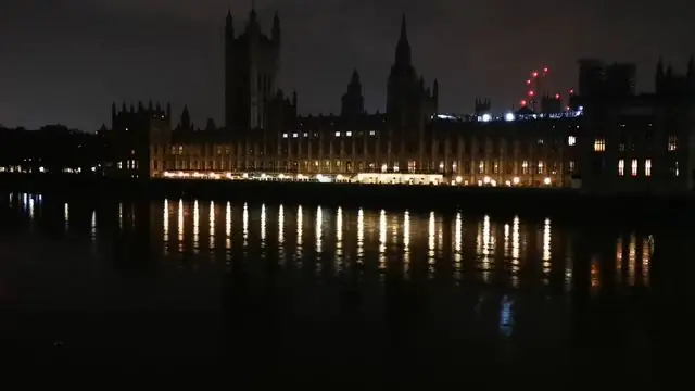 Scenic nighttime view of London's landmarks reflecting on the Thames.